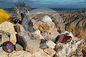 Close up of the big landmark on top of Cabezo del Sillon with a Virgin del Pilar, offerings and Buddhist flags in Maria de Huerva photo
