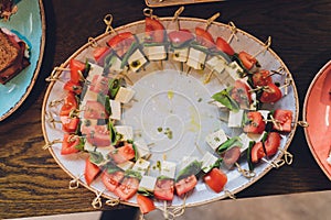 Close-up big plate with serving snack canapes fried bread tomato parsley and salami.