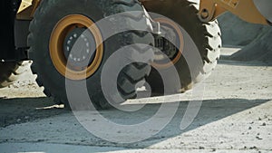 Close-up of big rotating wheels of working tractor