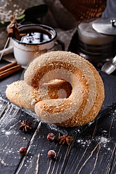 Close up of big sweet bagel on dark rustic wooden table.