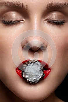 Close up of bijouterie ring with stone in red female mouth lips