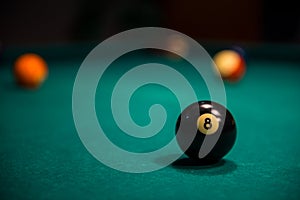 Close -up of billiard 8 ball on billiard table with other balls in the background