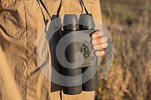 Close up of binoculars in a man`s hand