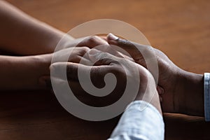 Close up of biracial couple hold hands having romantic moment