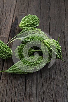 Close up Bitter melon bitter gourd cucumber or Momordica charantia in wooden bowl isolated on old wood table