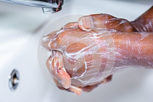 Close up of black African Australian woman washing hands with soap