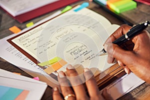 Close up of black businesswoman writing appointments on personal organizer