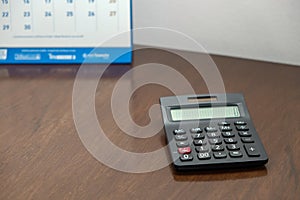 Close-up of black Calculator on wooden table