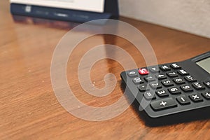 Close-up of black Calculator on wooden table