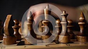 Close up of black chess pieces on board. Two rows of wooden figures on chessboard on black background. Concept of