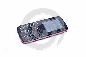 Close up of black colored cell phone with switches or keys on it isolated on white.