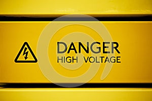 Close up of black danger high voltage sign on yellow background