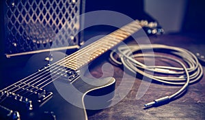 Close-up, black electric guitar on a dark background.