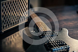 Close-up, black electric guitar on a dark background.