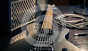 Close-up, black electric guitar on a dark background.