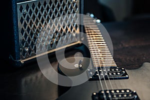 Close-up, black electric guitar on a dark background.