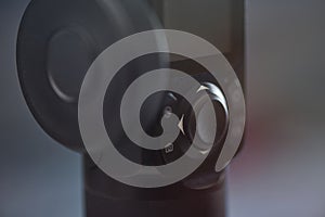 Close-up of black electronic device joystick control with directional arrows and buttons in soft lighting