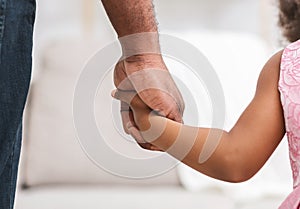 Close up of black father giving hand to his daughter