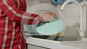 Close-up of black females hands washing dishware with detergent and sponge