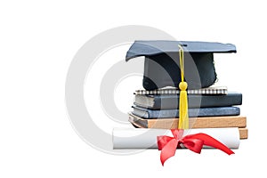 Close up black graduation cap and certificate paper with red ribbon on a stack of vintage books isolated on white background.
