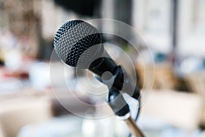 Close-up black iron microphone stands on the stage. Live music concert in a restaurant or bar in the evening