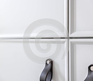 Close-up of black knobs on a white cabinet