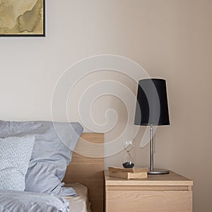 Close-up on black lamp on wooden nightstand