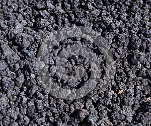 Close-up of black lava rocks on Mount Etna crater, Sicily, Italy. Warm volcanic lava stone formation. Basaltic lava