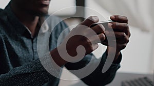 Close up of black man hands playing online internet mobile video games