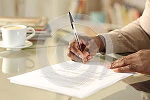 Black man hands singing contract on a desk