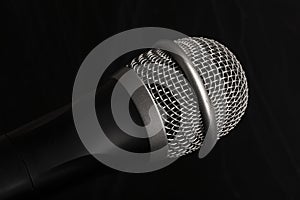 Close-up black microphone head isolated on black background