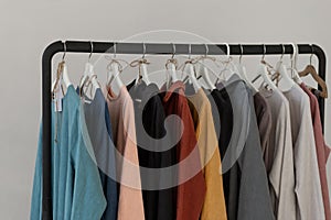 Minimalistic rack with linen colourful clothes on white studio background. photo