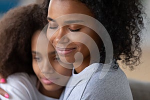 Close up of black mom hugging teenage daughter