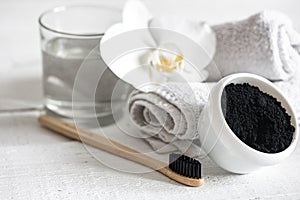 Close up of black natural teeth whitening powder and toothbrush