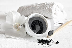 Close up of black natural teeth whitening powder and toothbrush