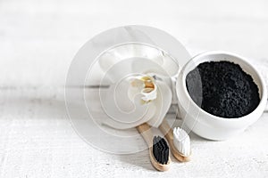 Close up of black natural teeth whitening powder and toothbrushes