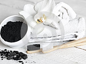 Close up of black natural teeth whitening powder and toothbrushes
