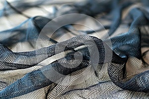 A close-up of black netting on white fabric, emphasizing the texture and pattern against a clean background. the focus is sha