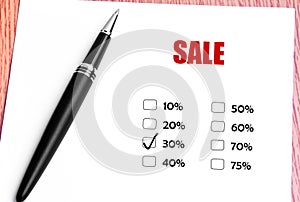 Close Up Black Pen And Checked 30% Discounted Rate At Sale Promotion