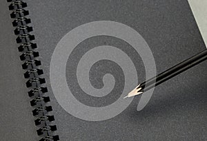 Close up at black pencil on blank black notebook,mock up for add