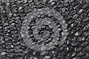 Close up of black plastic bubbles on a bubble wrap