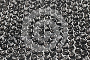 Close up of black plastic bubbles on a bubble wrap