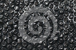 Close up of black plastic bubbles on a bubble wrap