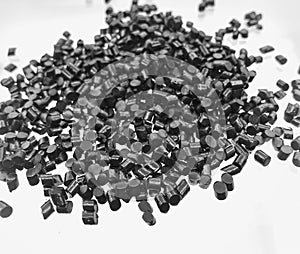 black plastic polymer granules on white background