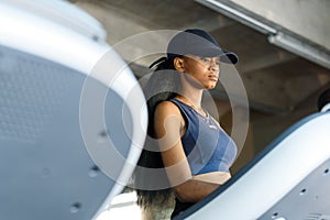 Close-up of black pretty african-american woman walking on a treadmill in the gym