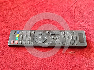 Close up black remotes tv with colorfull button