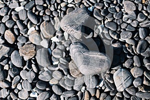 Close up of black rounded beach stones and pebble stones.