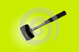 Close up black rubber mallet isolated on bright green background. Rubber hammer is a construction tool. Clipping path