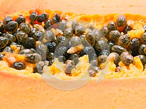 Close-up of black seeds in cut ripe papaya - selective focus.