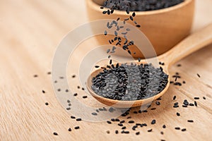 Close up of black sesame seed on wooden spoon in kitchen